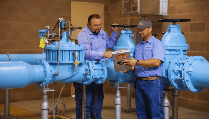 Two workers examining groundwater equipment.